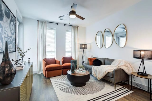 Gray sofa with blanket and orange chairs living room at Signature Music Row in Nashville Student Accommodation