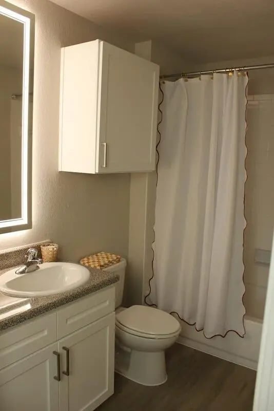 Sink toilet white cabinet shower curtain Bathroom at 21 Pearl in Austin Student Accommodation