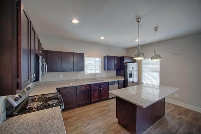 Dark cabinets stove island and appliances kitchen at The Collective at Kennesaw in Kennesaw Student Accommodation