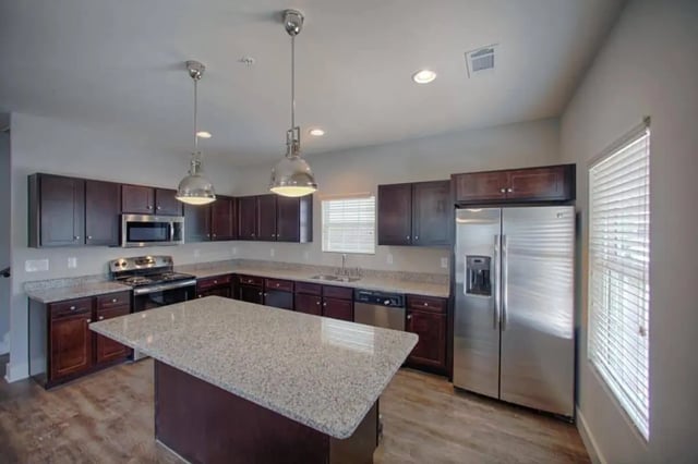 Kitchen island with granite counters and stainless steel appliances kitchen at The Collective at Kennesaw in Kennesaw Student Accommodation