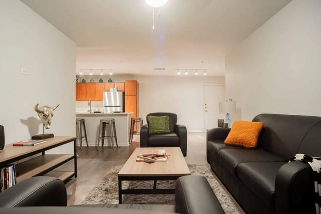 Leather sofas coffee table kitchen area living room at Sparq On Rio in Austin Student Accommodation