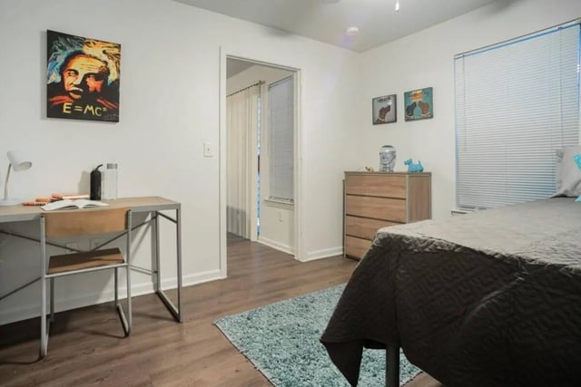 Desk lamp open book dresser and bed bedroom at Sparq On Rio in Austin Student Accommodation
