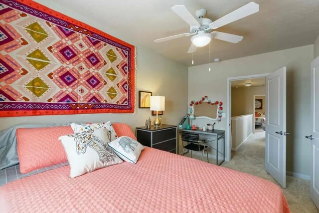 Pink bed tapestry desk and ceiling fan bedroom at The Collective at Lawrence in Lawrence Student Accommodation