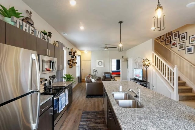 Stainless steel appliances granite island living room exterior at The Collective at Lawrence in Lawrence Student Accommodation
