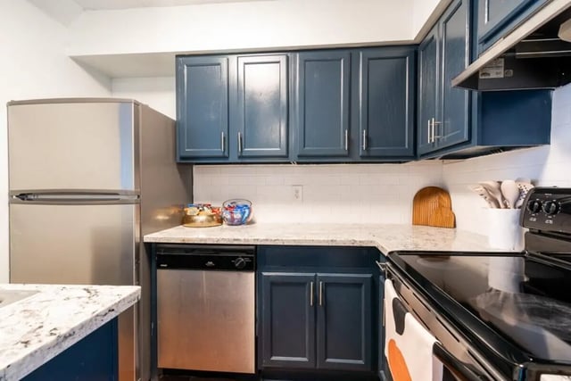 Stainless steel refrigerator dishwasher dark blue cabinets kitchen at Logan Square in Auburn Student Accommodation