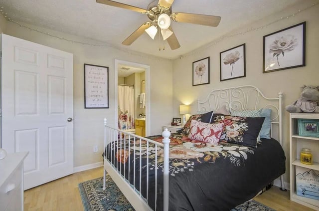 White metal bed floral bedding framed art bedroom at Logan Square in Auburn Student Accommodation