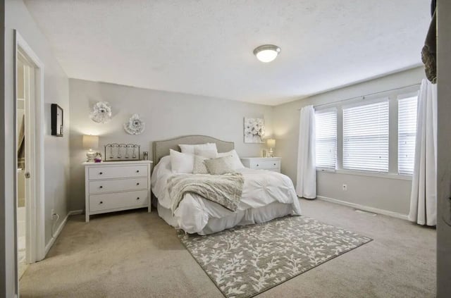Bed with white bedding floral rug bedroom at Logan Square in Auburn Student Accommodation