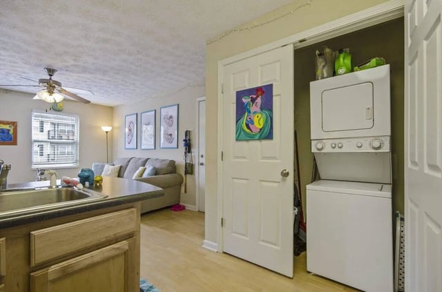 Kitchen living area with stacked washer dryer. at Logan Square in Auburn Student Accommodation