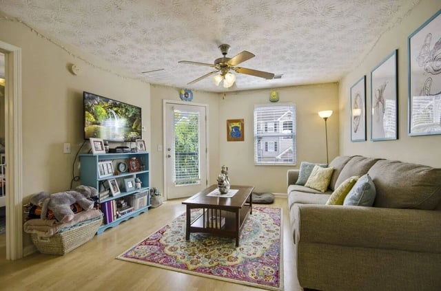 Sofa television bookshelf and rug living room at Logan Square in Auburn Student Accommodation