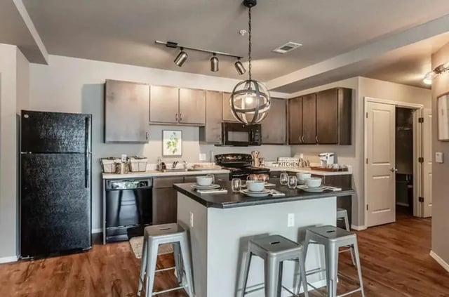 Modern kitchen island black refrigerator dishware kitchen at Champions' Club in Fayetteville Student Accommodation