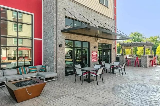 Outdoor seating area with fire pit and grill exterior at Champions' Club in Fayetteville Student Accommodation