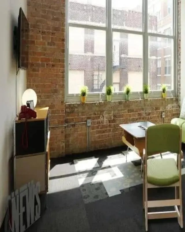 TV plants desk table chair and floor living room at The Letterman Chicago in Chicago Student Accommodation