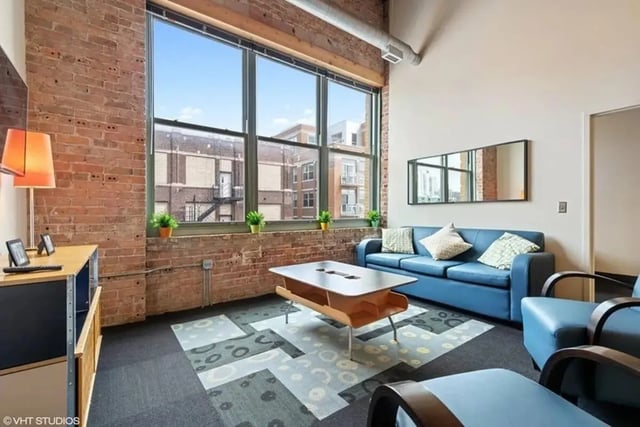 Blue sofa coffee table on patterned rug living room at The Letterman Chicago in Chicago Student Accommodation