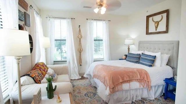 Bed sofa rug lamps and wall decor bedroom at Balcony Auburn in Auburn Student Accommodation