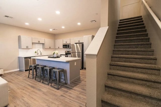 Modern kitchen with island and staircase interior at Lofts on 8th in Tempe Student Accommodation