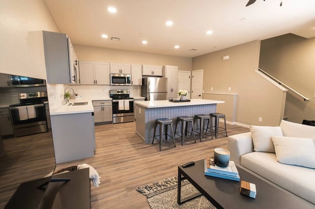 Modern kitchen with island and living area. at Lofts on 8th in Tempe Student Accommodation