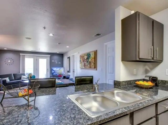 Kitchen with sink and living area beyond at The Landings at Chandler Crossings in East Lansing Student Accommodation