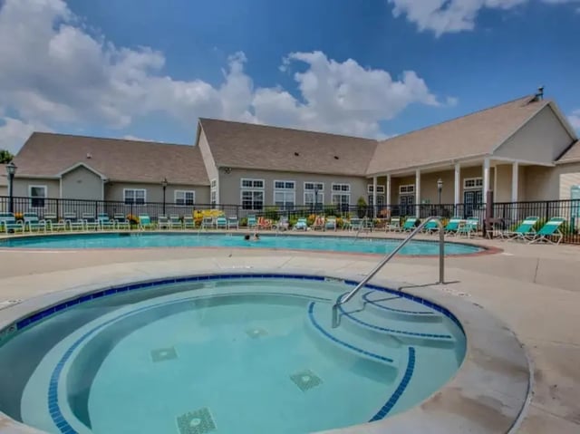 Hot tub and swimming pool with lounge chairs exterior at The Landings at Chandler Crossings in East Lansing Student Accommodation