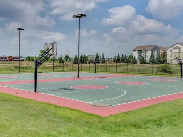 Basketball court with hoops and apartments exterior at The Landings at Chandler Crossings in East Lansing Student Accommodation