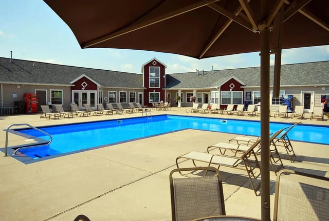 Blue swimming pool with lounge chairs exterior at Tremont Student Living in State College Student Accommodation