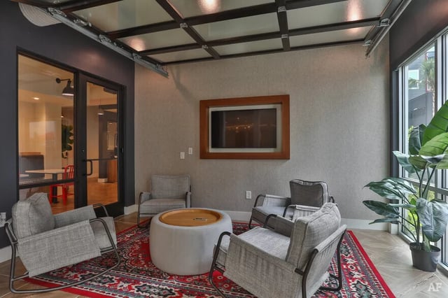 Four chairs and ottoman with TV living room at The Nine at Columbia in Columbia Student Accommodation