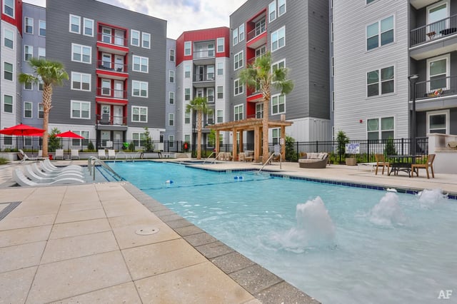 Pool lounge chairs and building exterior pool area at The Nine at Columbia in Columbia Student Accommodation