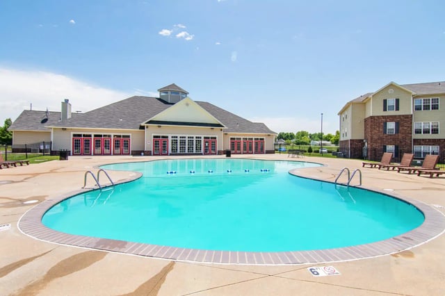 Large blue pool with lounge chairs and building exterior at 2909 Oliver in Wichita Student Accommodation
