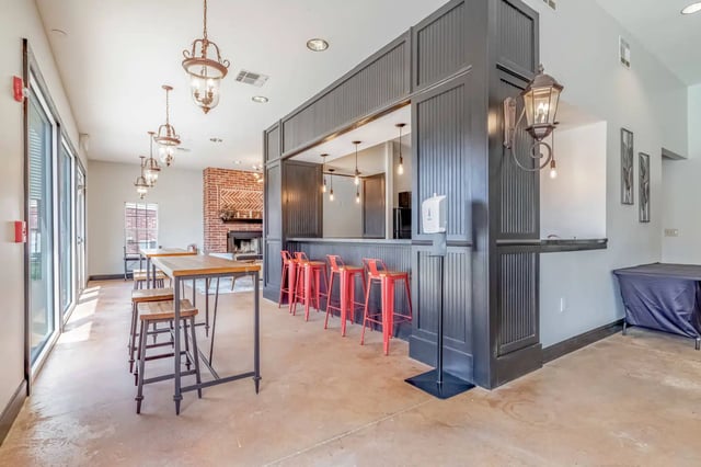 Bar with red stools and high tables common area at 2909 Oliver in Wichita Student Accommodation