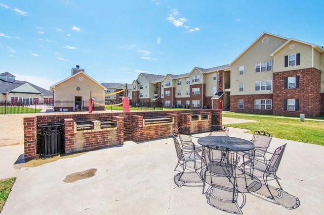 Grill area with tables chairs and volleyball net exterior at 2909 Oliver in Wichita Student Accommodation