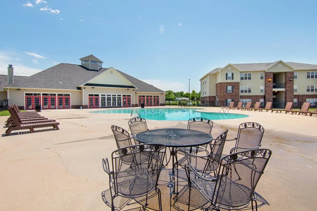 Outdoor seating chairs and table beside pool at 2909 Oliver in Wichita Student Accommodation