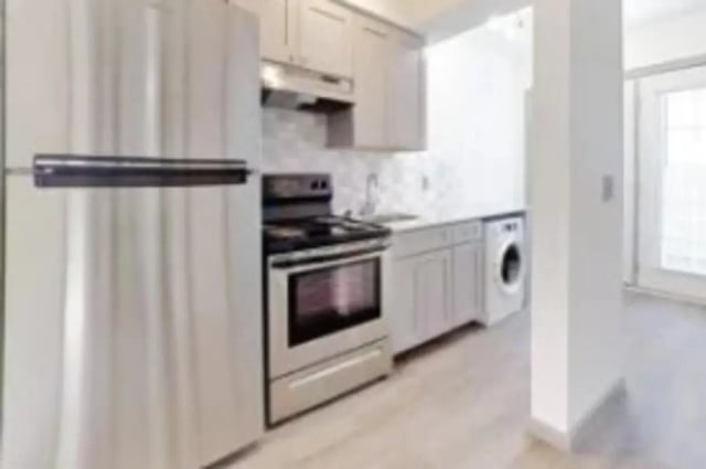 Stainless steel fridge stove cabinets laundry area kitchen at The District at Clemson in Clemson Student Accommodation