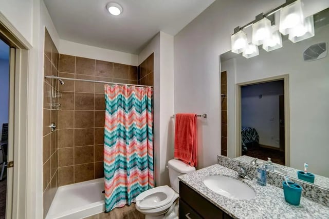 Toilet sink shower with colorful curtain bathroom at Riverfront Village in Tuscaloosa Student Accommodation