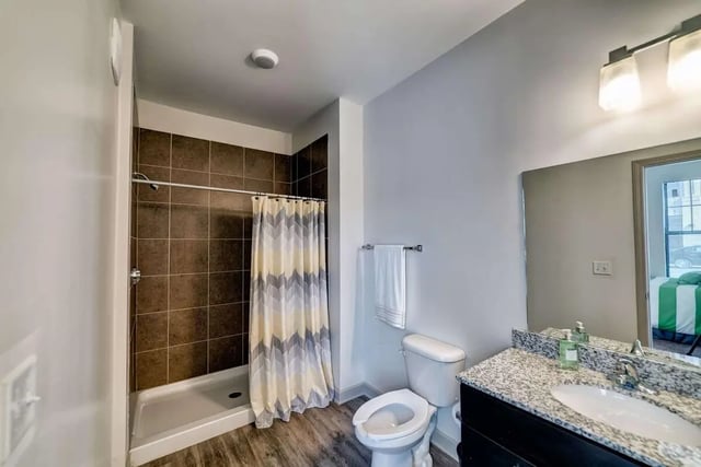 Tiled shower patterned curtain toilet and sink bathroom at Riverfront Village in Tuscaloosa Student Accommodation
