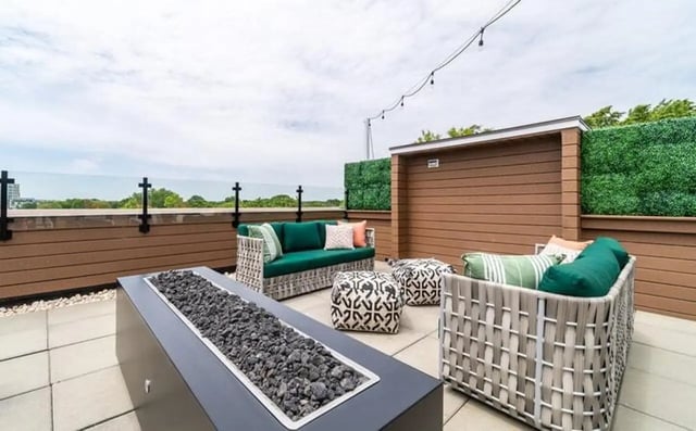 Outdoor seating with fire pit and pillows patio at The Warehouse Apartments Chapel Hill in Chapel Hill Student Accommodation