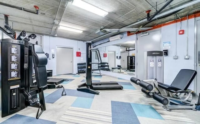 Weight machines treadmills and weights gym area at The Warehouse Apartments Chapel Hill in Chapel Hill Student Accommodation