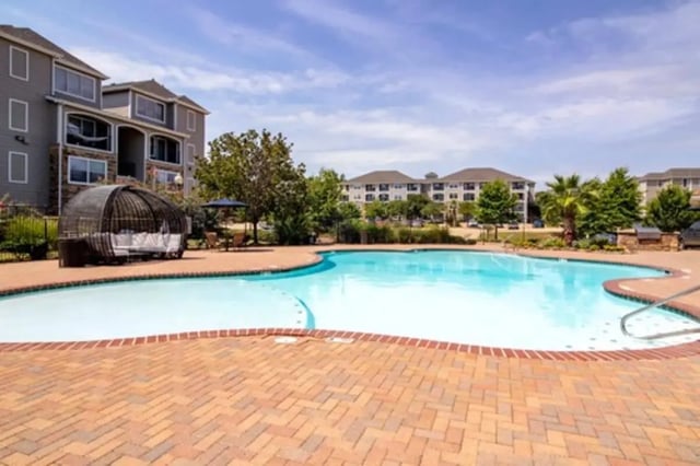 Resort-style pool with lounge furniture and buildings exterior at Gateway at Huntsville in Huntsville Student Accommodation