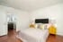 Bed with yellow nightstands and lamps bedroom at The Den at Clemson in Clemson Student Accommodation