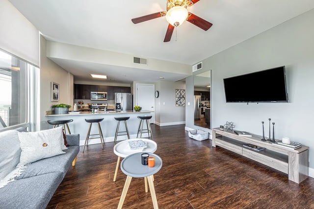 Sofa kitchen island bar stools and television living room at 21 Rio in Austin Student Accommodation