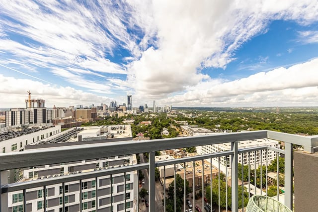 Railing overlooking city buildings and greenery exterior at 21 Rio in Austin Student Accommodation