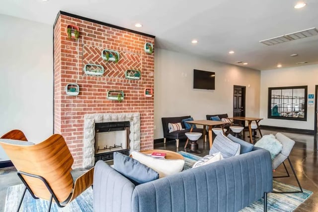 Brick fireplace couches tables and chairs living room at Gamecock Village in Jacksonville Student Accommodation