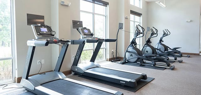 Treadmills and ellipticals with TVs gym at The Armory in Huntsville Student Accommodation