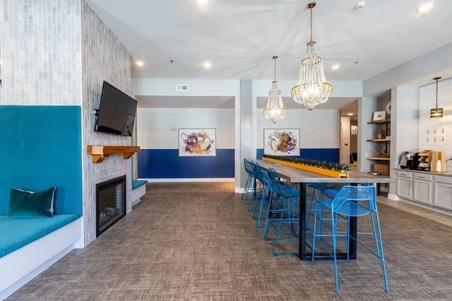Blue seating area fireplace and long table lounge at Eastern on 10th in Greenville Student Accommodation