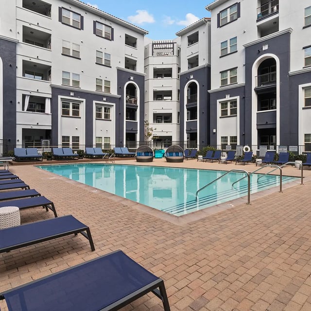 Apartment complex buildings surrounding a pool with lounge chairs Exterior at Iconic on Alvarado in San Diego Student Accommodation