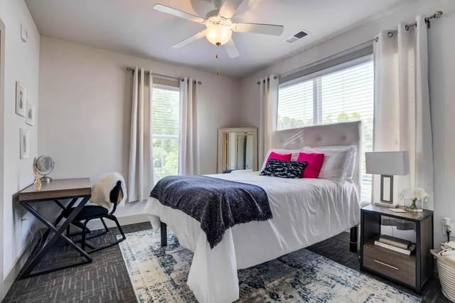 Bed desk chair rug and ceiling fan bedroom at 1820 at Centennial in Raleigh Student Accommodation