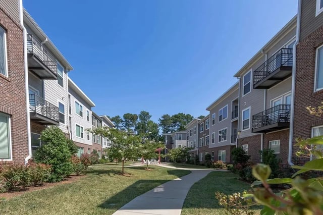 Apartment buildings with balconies and green courtyard exterior at 1820 at Centennial in Raleigh Student Accommodation