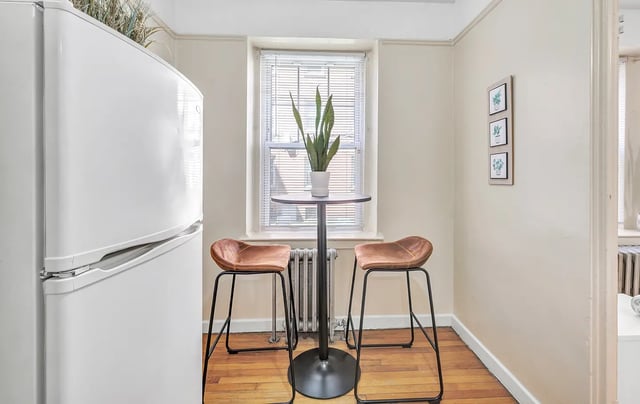 Fridge table two bar stools and plant kitchen at Howe Place Apartments in New Haven Student Accommodation