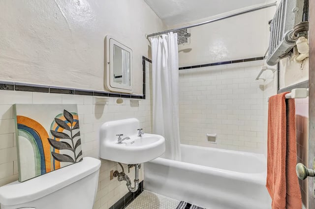 Toilet sink tub shower curtain bathroom at Howe Place Apartments in New Haven Student Accommodation