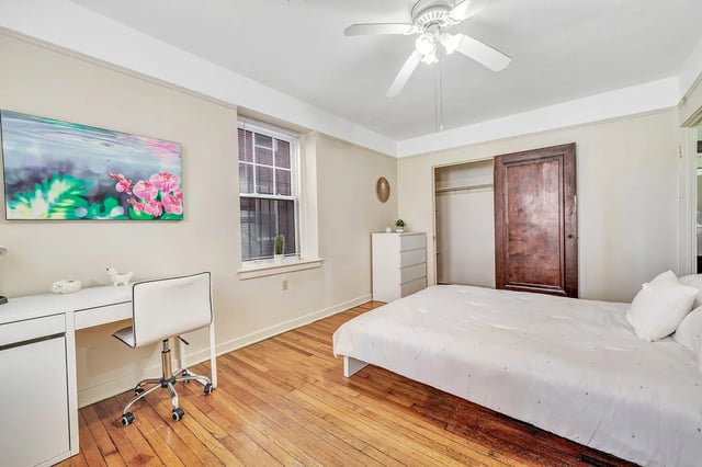 Bed desk chair closet painting and fan bedroom at Howe Place Apartments in New Haven Student Accommodation