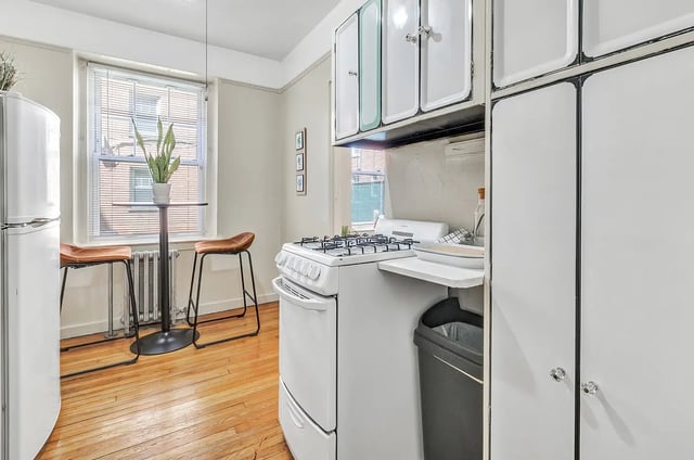 White refrigerator two stools stove cabinets kitchen at Howe Place Apartments in New Haven Student Accommodation