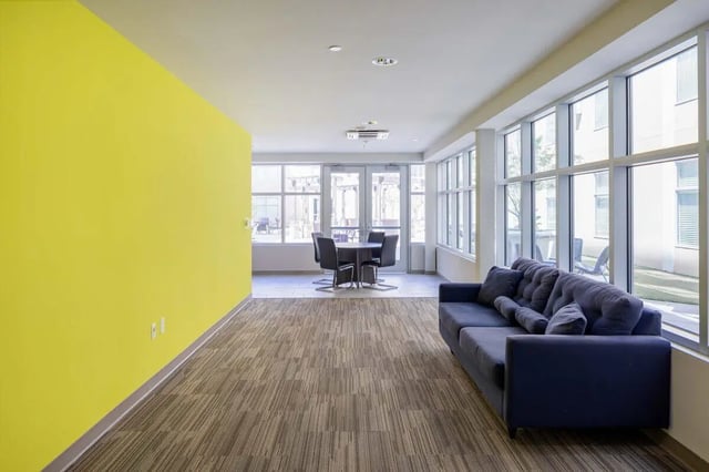 Blue couch and dining table in common area at 200 Edgewood in Atlanta Student Accommodation